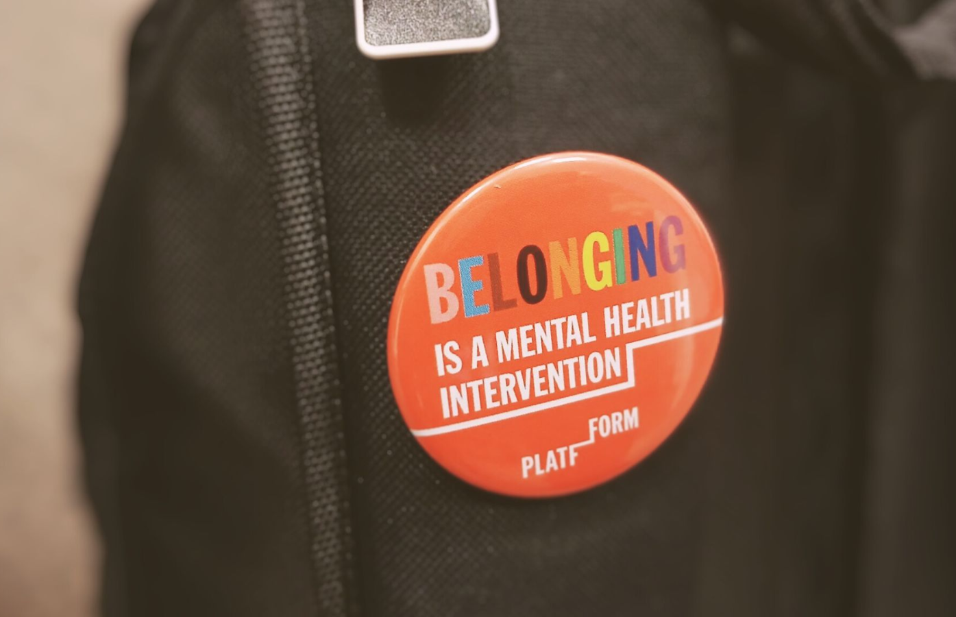 Round red Platfform badge with wording 'Belonging is a mental health intervention'